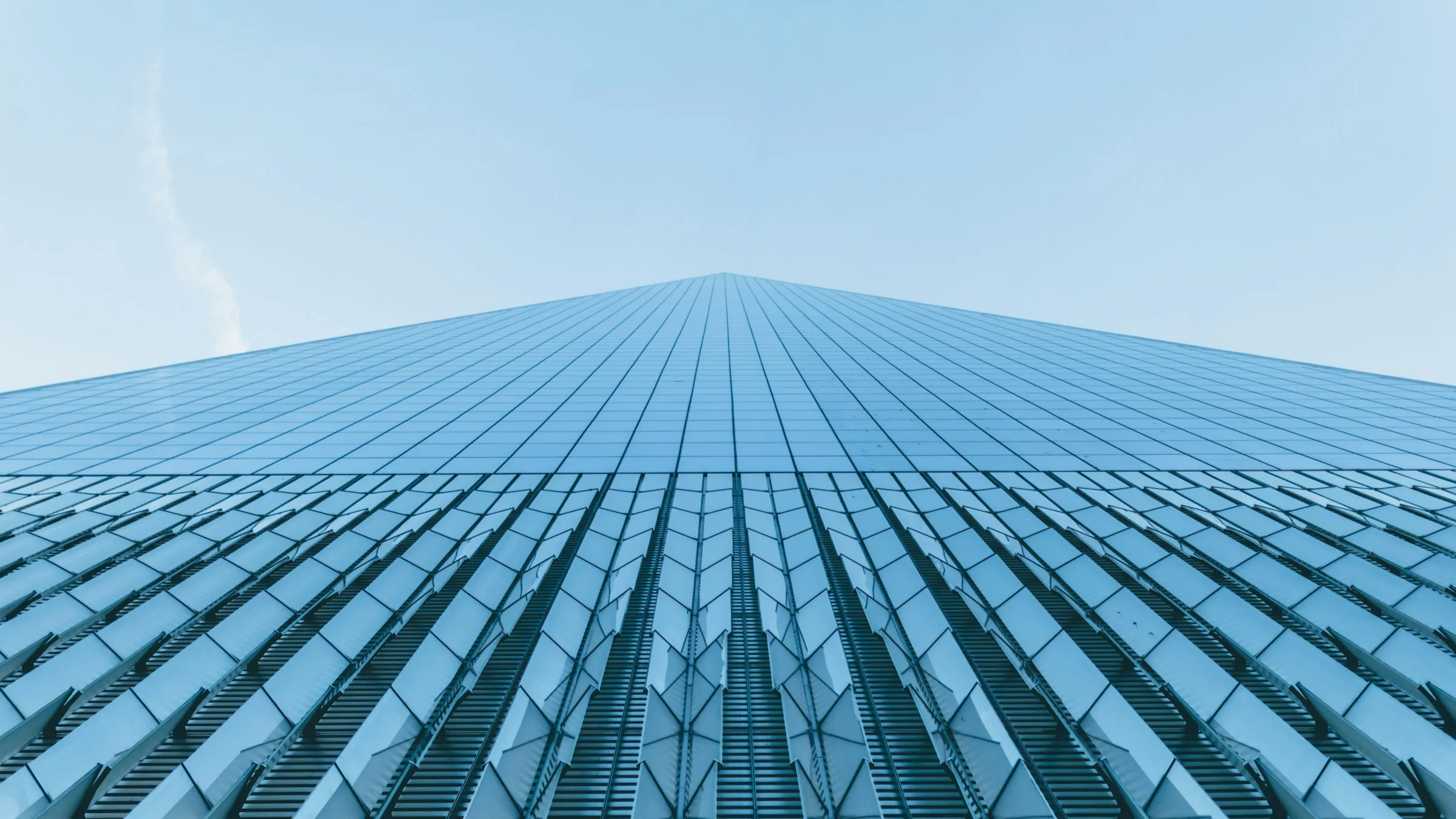 Modern office tower facade rising under a clear sky.